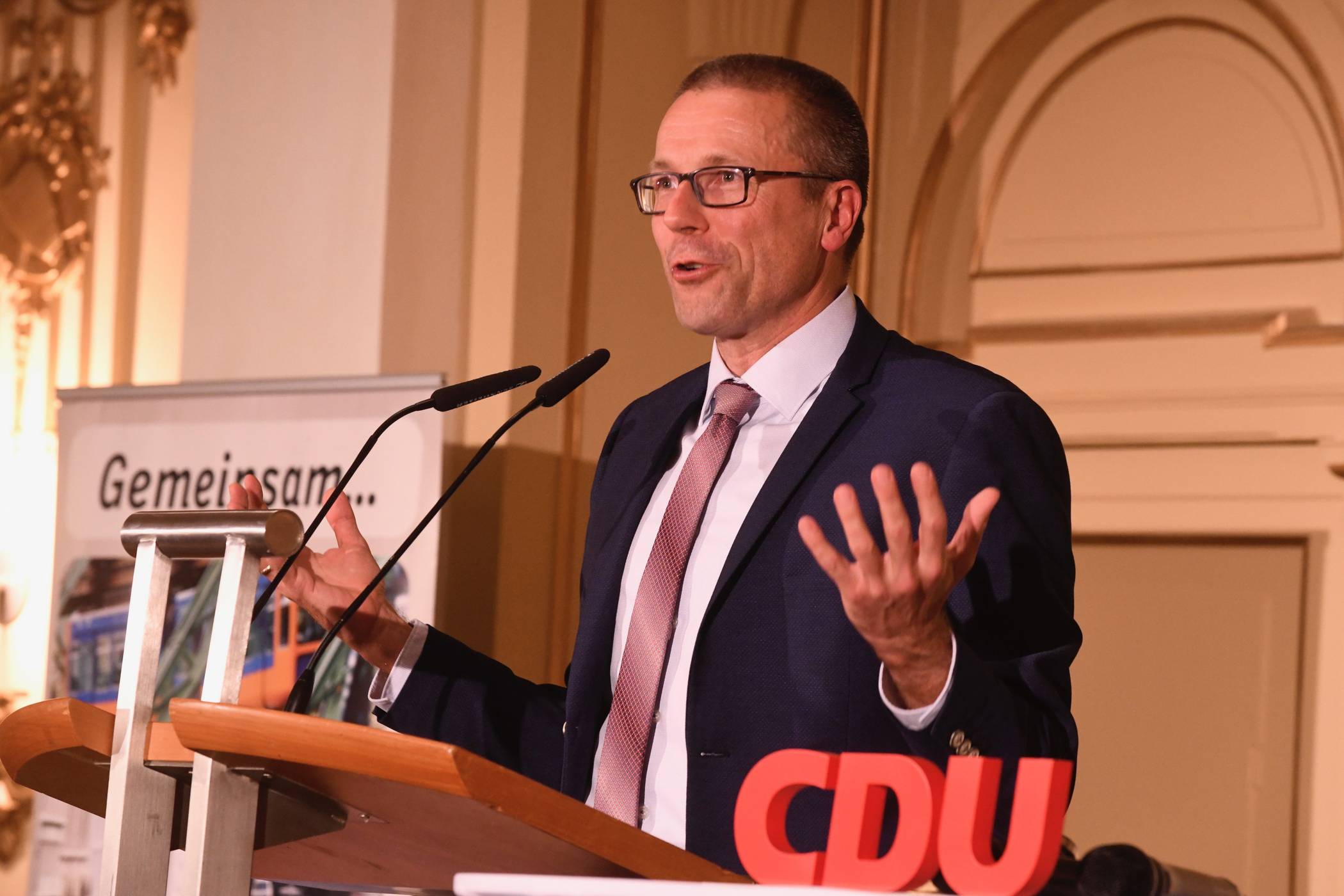 Uwe Schneidewind auf dem Rednerpult zwischen dem CDU-Slogan „Gemeinsam“ und dem Schriftzug der Partei.
